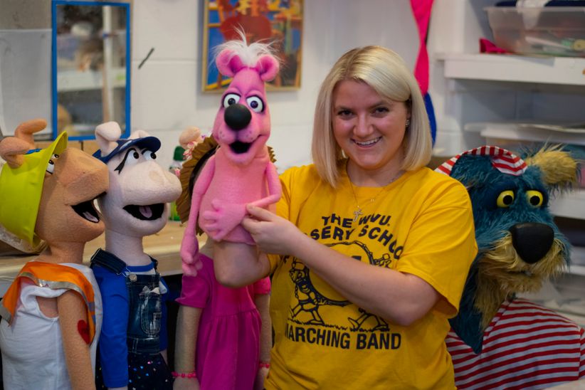 Alexandra Ashworth holds a puppet and smiles